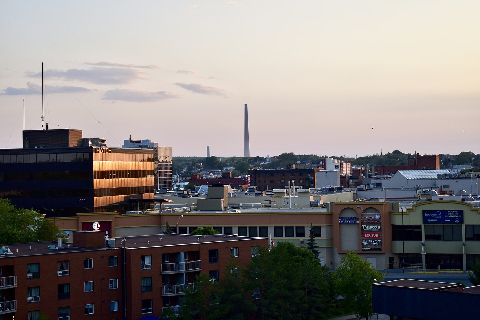 Downtown Greater Sudbury at golden hour with the Superstack on the skyline, photographed by Jason Paris